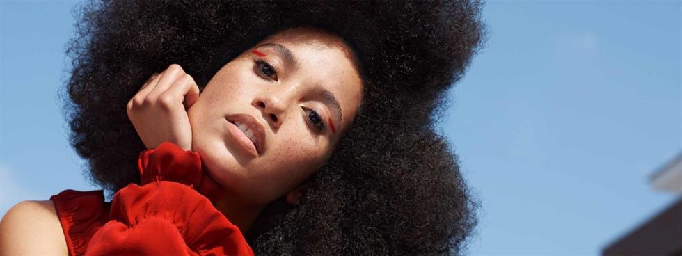 Woman wearing an afro styled in a new curls look.